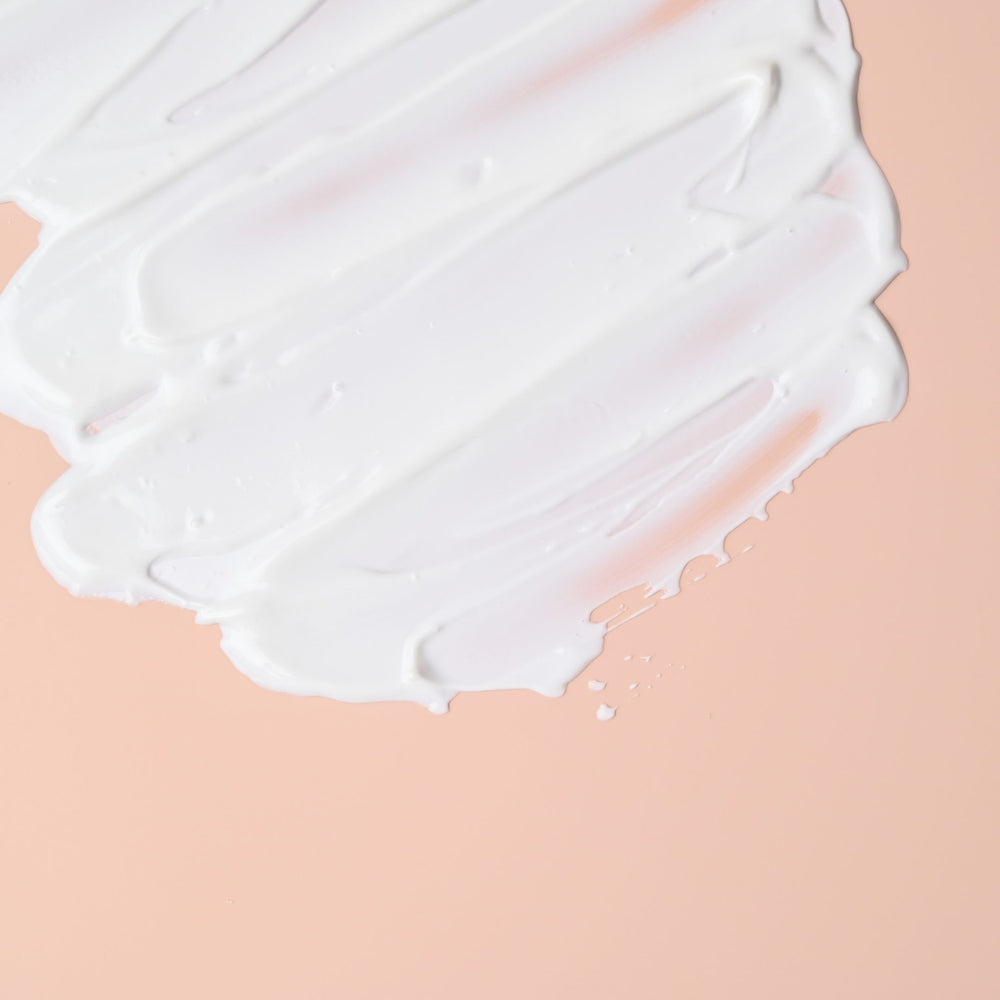 Een witte vloeistof op een roze oppervlak - Hydraterende Nachtcrème met Hyaluronzuur & Arganolie