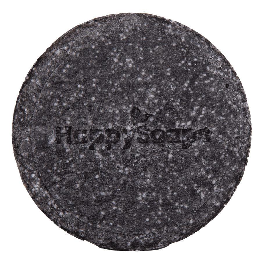 Een zwarte ronde shampoo bar met tekst - The Happy Panda. Handgemaakt in Nederland met bamboe, geactiveerd houtskool, sheaboter, quinoa en olijfolie. Geschikt voor intense reiniging en herstel van hoofdhuid en haar. 100+ wasbeurten zonder plastic afval. Eenvoudig in gebruik.