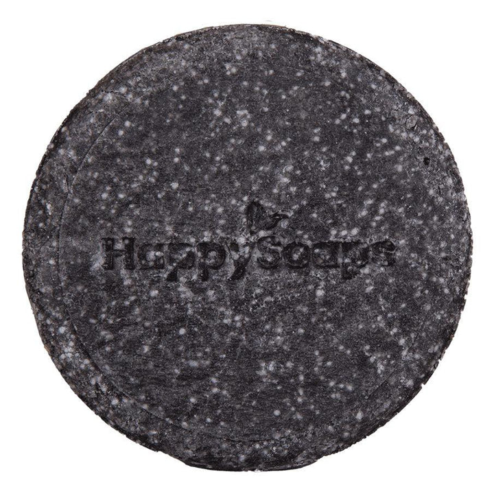 Een zwarte ronde shampoo bar met tekst - The Happy Panda. Handgemaakt in Nederland met bamboe, geactiveerd houtskool, sheaboter, quinoa en olijfolie. Geschikt voor intense reiniging en herstel van hoofdhuid en haar. 100+ wasbeurten zonder plastic afval. Eenvoudig in gebruik.